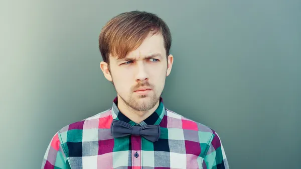 Young thinking man in shirt with bowtie — Stock Photo, Image