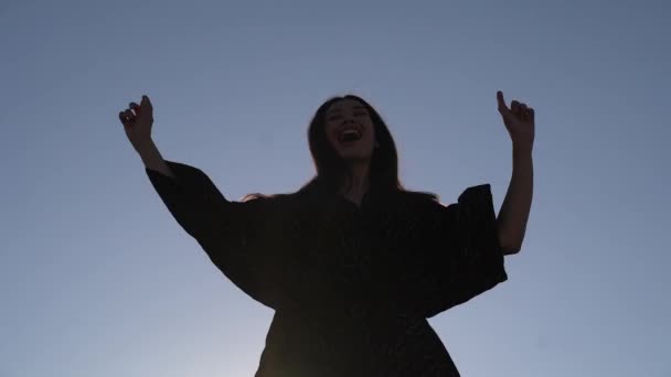 Chica atractiva bailando contra el cielo al atardecer — Vídeos de Stock