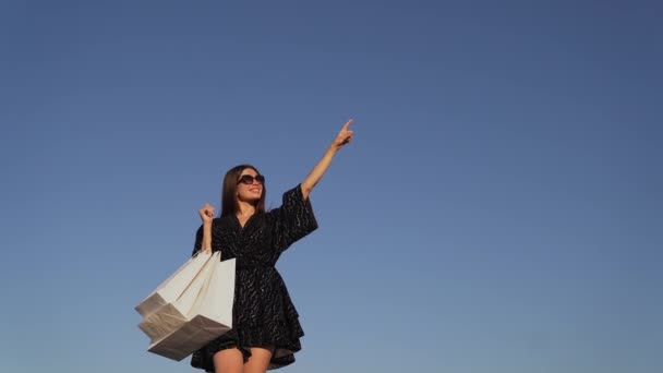 Chica de lujo sostiene bolsas de compras al aire libre con lugar para el texto — Vídeo de stock