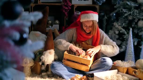 Fille rousse dans un chapeau rouge Santa avec décoration de Noël — Video