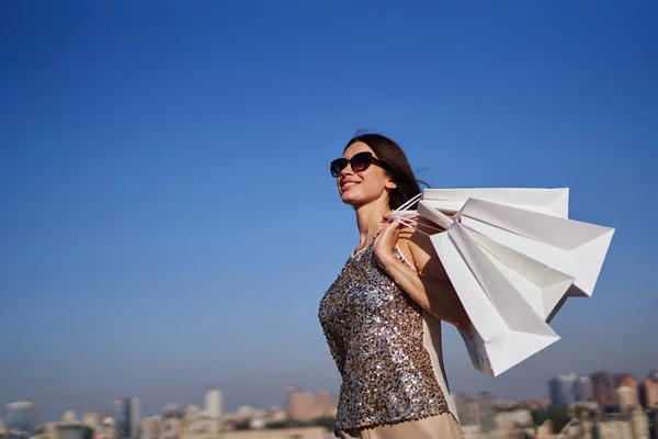 Moda mulher de estilo com sacos de compras no fundo urbano — Fotografia de Stock