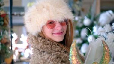 Şapkalı çekici kız Noel alışverişi yapıyor.