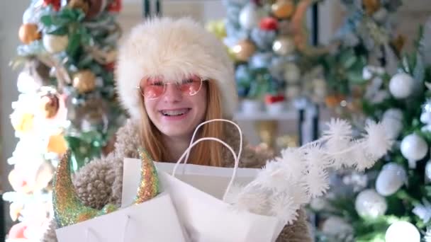 Girl happy customer with christmas tree decorations in bag — Stockvideo