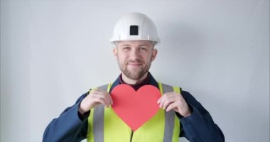 Supervisor in helmet showing red heart for Valentines Day