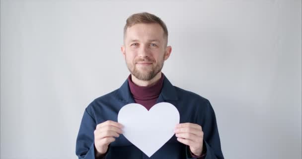 Bearded man worker portrait with white paper heart smiling — 비디오