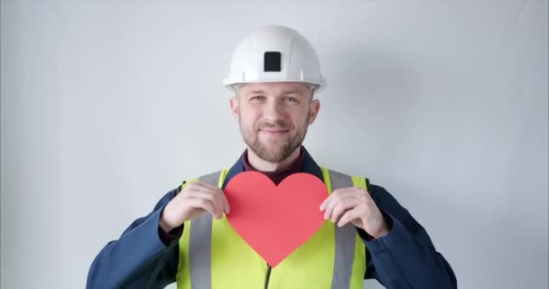 Supervisor in helmet showing red heart for Valentines Day — Wideo stockowe