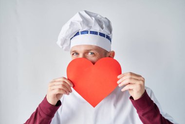 Valentines Day concept: male chef in uniform with red heart