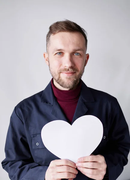 Bearded mechanic or repairman holding white heart shape — Fotografia de Stock
