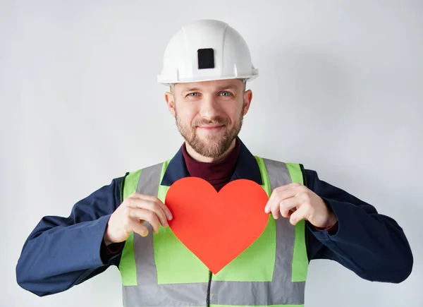 Valentines Day: male worker in hard hat showing red heart
