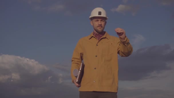 Contratista de construcción en obra corrigiendo el casco duro — Vídeos de Stock
