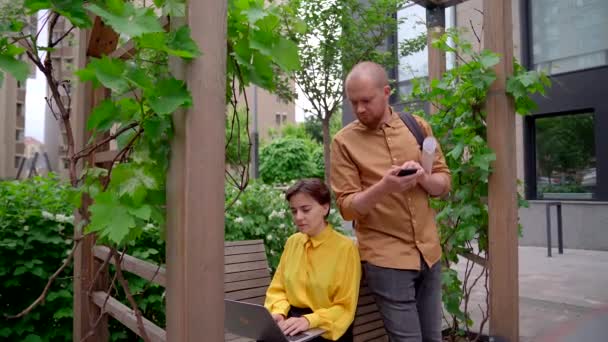 Business team bespreekt project outdoor op park met laptop — Stockvideo