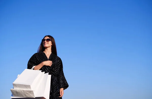 Tempo de compras: menina morena em vestido preto e óculos de sol — Fotografia de Stock