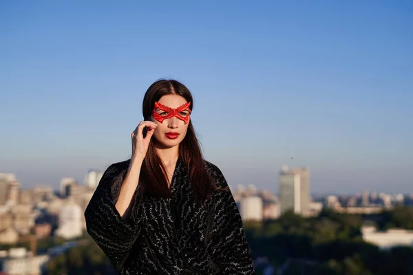 Femme super-héros masquée sur fond bleu ciel et urbain — Photo