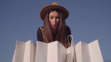 Alışveriş torbalarına bakan inanılmaz mutlu kadın.