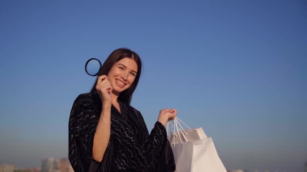 Felice ragazza sorridente con lente di ingrandimento alla ricerca di vendite — Video Stock