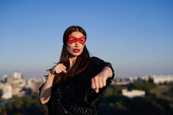 戴面具的女超级英雄用手在城市的视野下表演拳击 — 图库照片