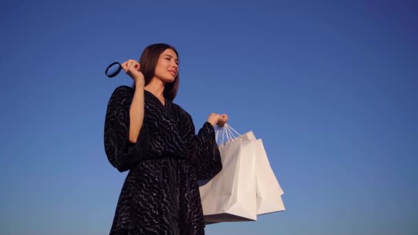 Roztomilé stylové dívka s lupou a nákupní tašky — Stock video