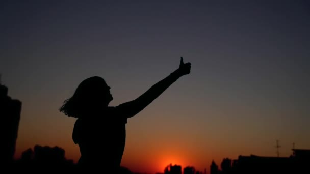 Силуэт счастья женщина танцует делая большие пальцы вверх жесты — стоковое видео