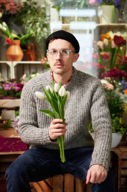 Lale çiçeği buketi tutan yakışıklı bir çiçekçi.