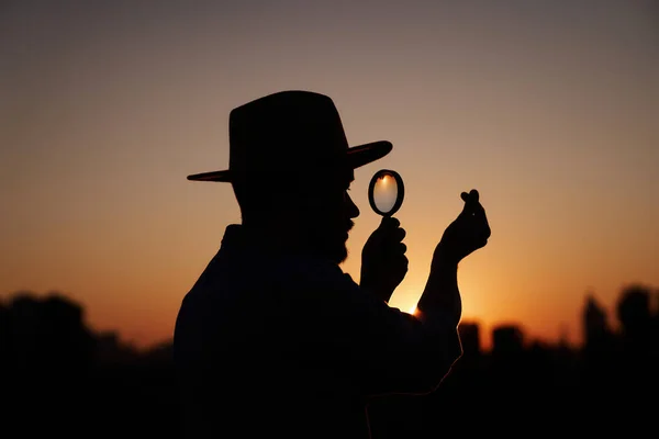 Homem silhueta com lupa e pequeno gesto cardíaco Imagem De Stock