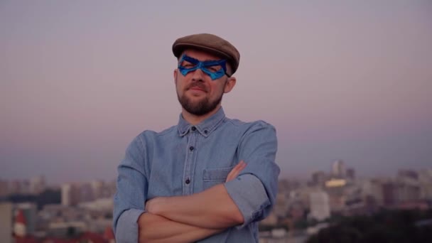 Masque masculin bleu super héros avec bras croisés et vue urbaine — Video