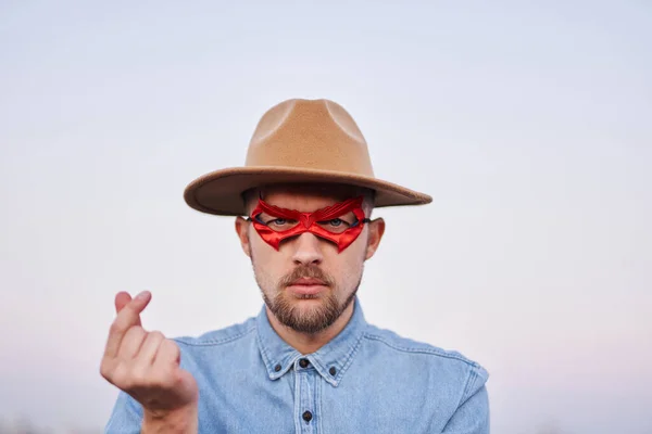 Man in superhero red mask and hat showing korean mini heart — Stock Photo, Image