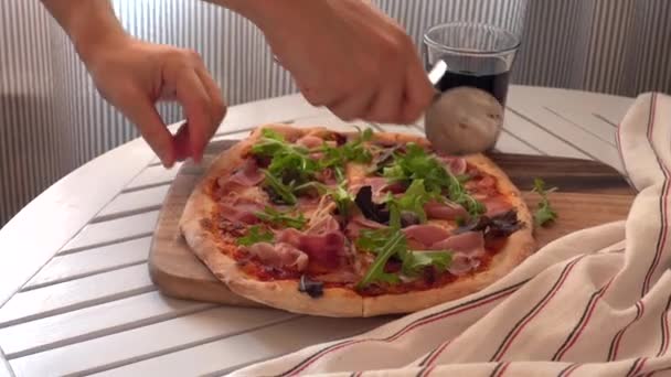 Рука режет вкусную итальянскую пиццу специальным ножом. — стоковое видео
