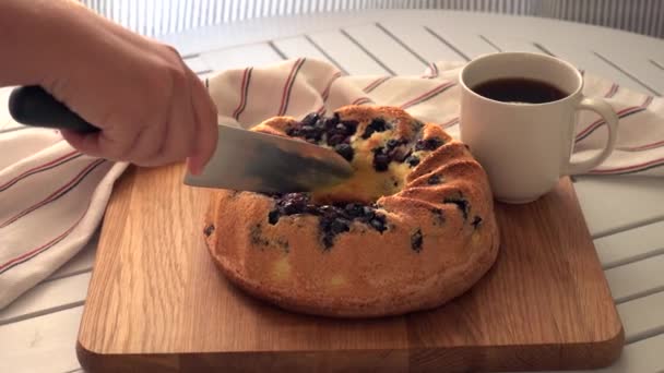 Kobieta kroi kawałek smacznego ciasta wiśniowego na drewnianej desce do krojenia — Wideo stockowe
