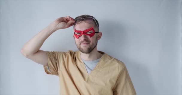 Söt manlig läkare sjuksköterska i röd superhjälte mask och glasögon — Stockvideo