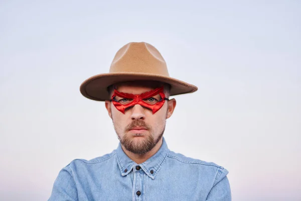 Serious expression male posing in superhero red mask and hat — Stock Photo, Image