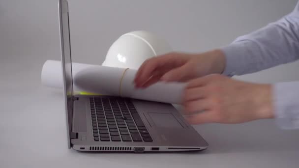 Ingenieur met blauwdrukken en helm met laptop computer — Stockvideo