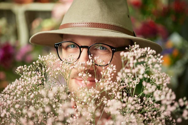Χαρούμενος άντρας με γυαλιά ηλίου και καπέλο σε μπουκέτο από φρέσκα λουλούδια — Φωτογραφία Αρχείου