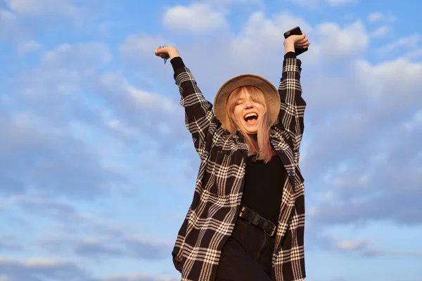 Online shopping: triumph dancing girl in hat on sky background — Foto de Stock