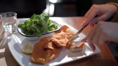 Çatal ve bıçakla geleneksel Avusturya sosis şnitzeli yemek.