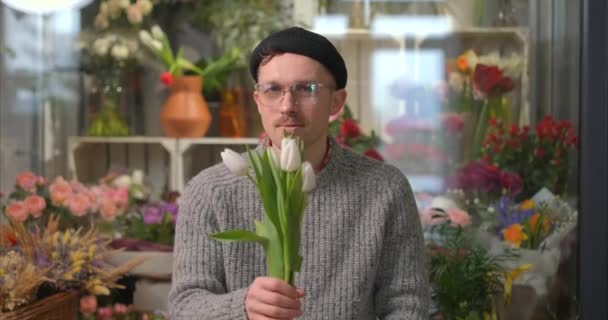 Maschio in occhiali tenendo fuori bouquet di tulipani bianchi freschi, 4k — Video Stock