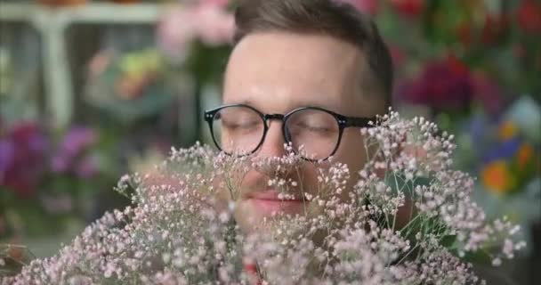 Om vesel în ochelari mirosind buchet de flori proaspete, 4k — Videoclip de stoc