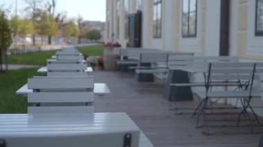 Rows of tables and chairs in a restaurant terrace outdoor. An empty cafe without customers due to the coronavirus pandemic. High quality 4k footage