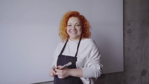 Positive Caucasian Female Painter Holding Paintbrushes Posing White Canvas Background — Wideo stockowe