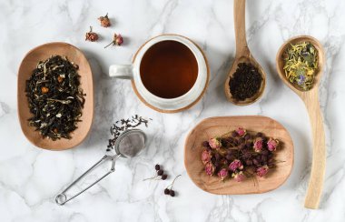 Bir fincan çay ve çay, ahşap kaşıklar ve tabaklar içinde.