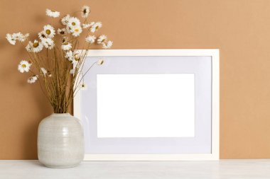 Güzel bir buket kuru papatya ile boş resim çerçevesi