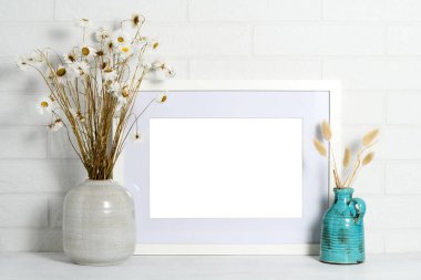 Kuru bitkilerin güzel buketleriyle boş resim çerçevesi