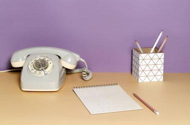 Menekşe arkaplanda ofis içi aksesuarları olan masa