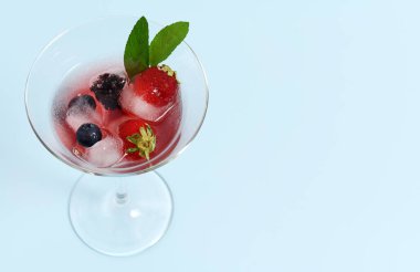 Mavi arka planda taze böğürtlenli cam.