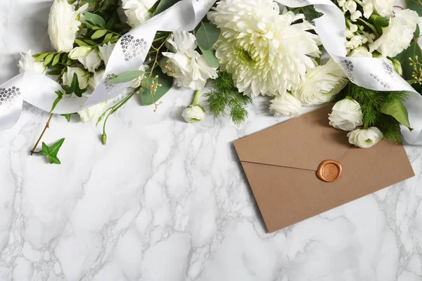 Beautiful arrangement of envelope, ribbon and white flowers flowers