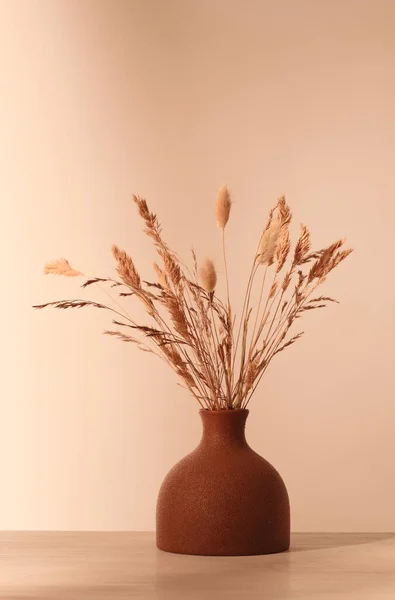 Vase with dried grass in brown tones