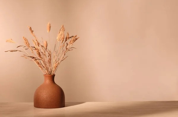 Vase with dried grass in brown tones