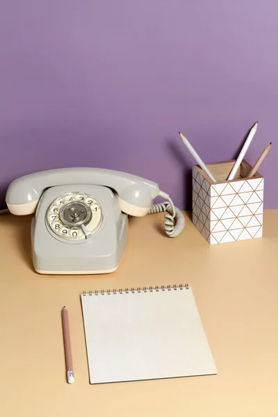 Table with intage office accessories on violet background