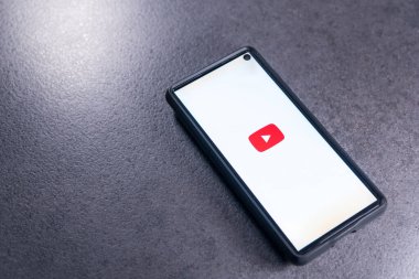 Kiev, Ukrayna - 24 Kasım 2021: Akıllı telefon ekranda video servisi YouTube ile masada yatıyor.