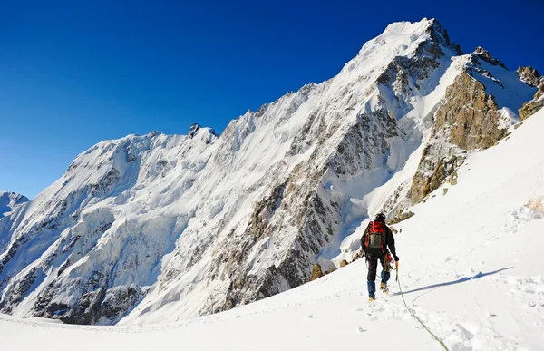 Climber reaching the summit of mountain — Stock Photo, Image