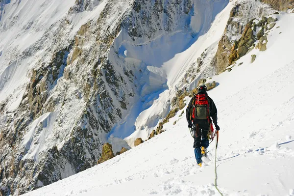 Horolezec dosáhne vrcholu hory — Stock fotografie